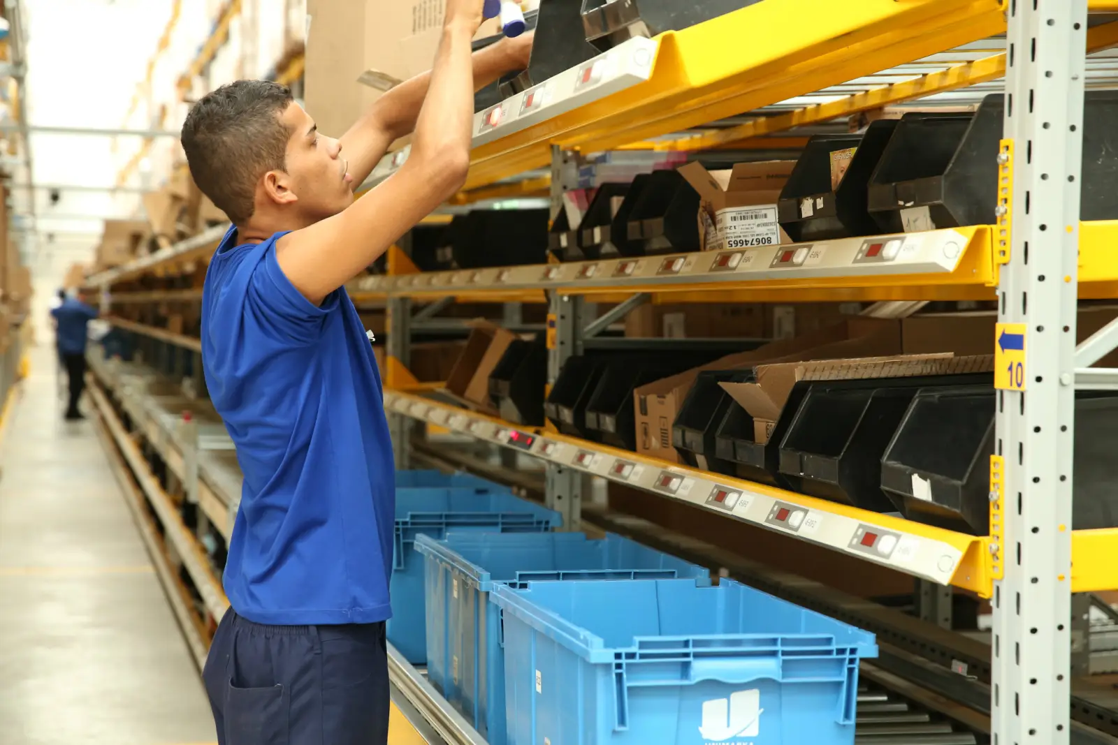 Colaborador da Unimarka separando pedidos nas estantes